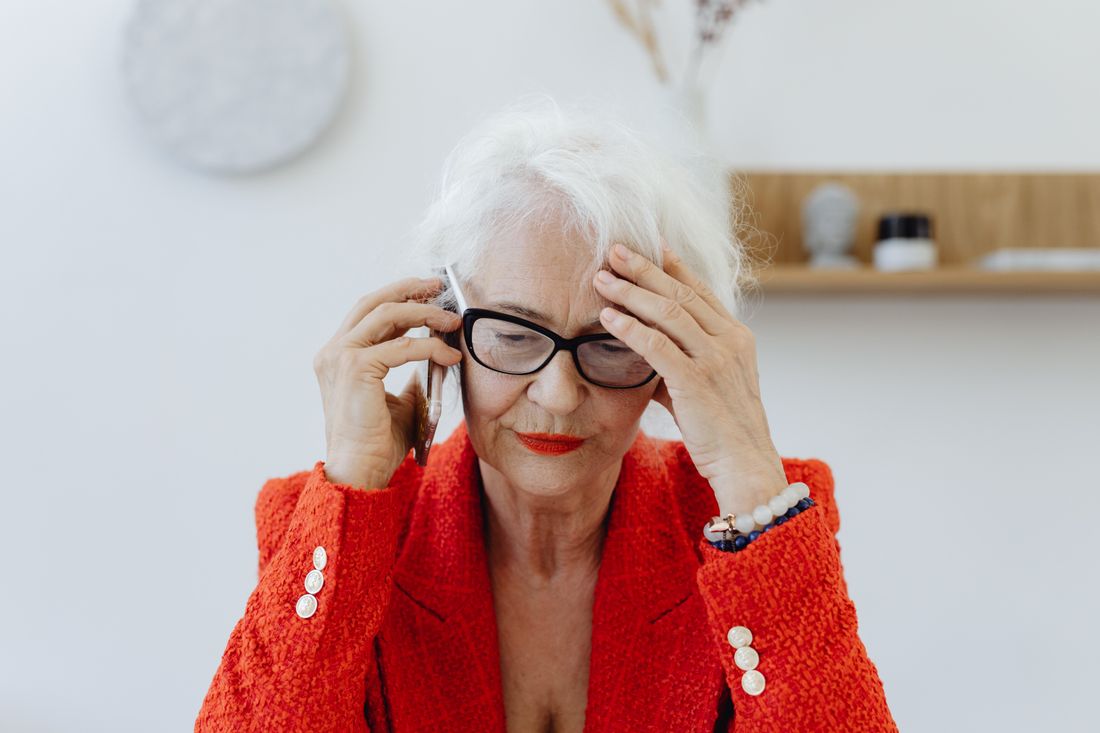 A senior woman looking stressed during a phone call