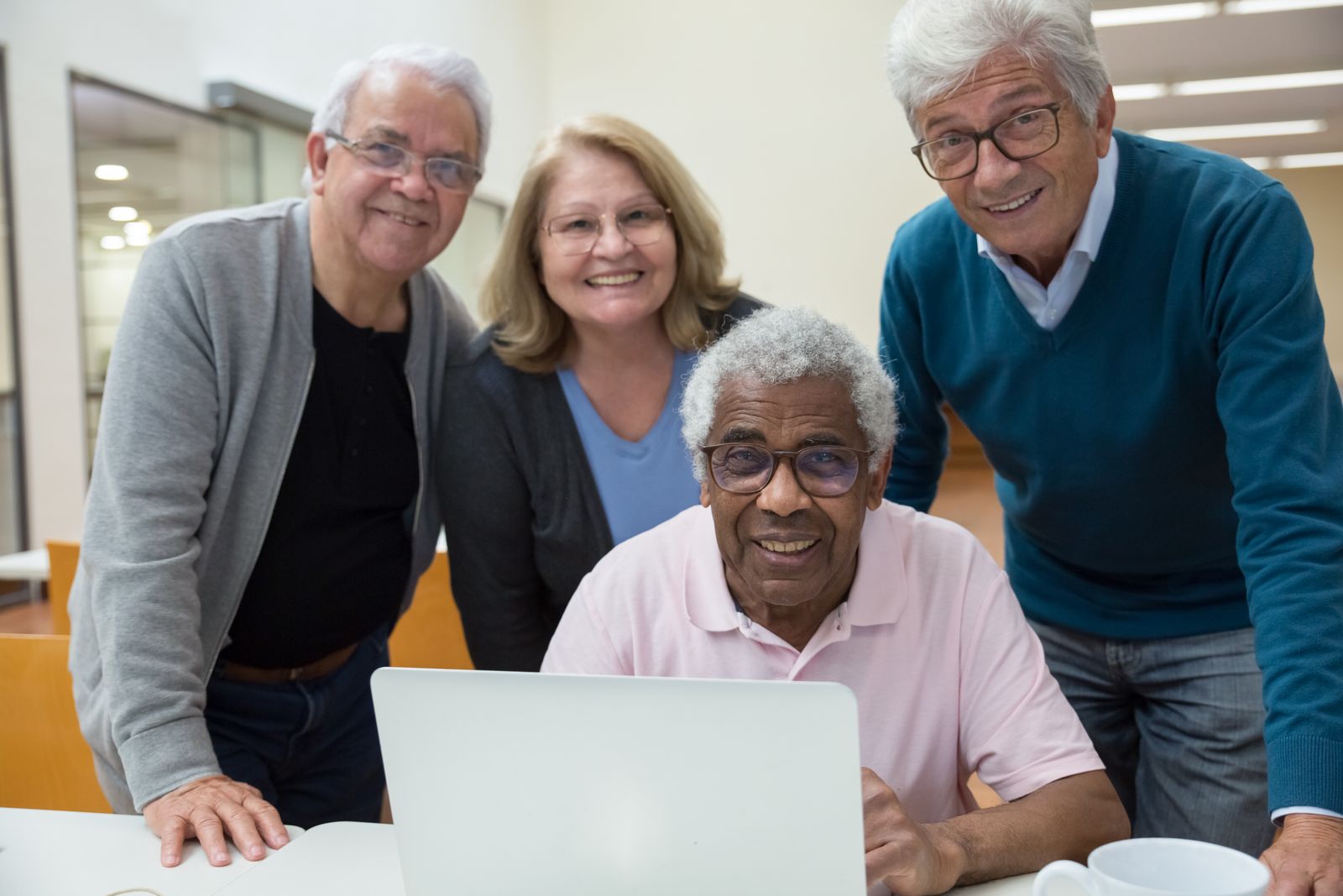 Older adults learning together at a laptop