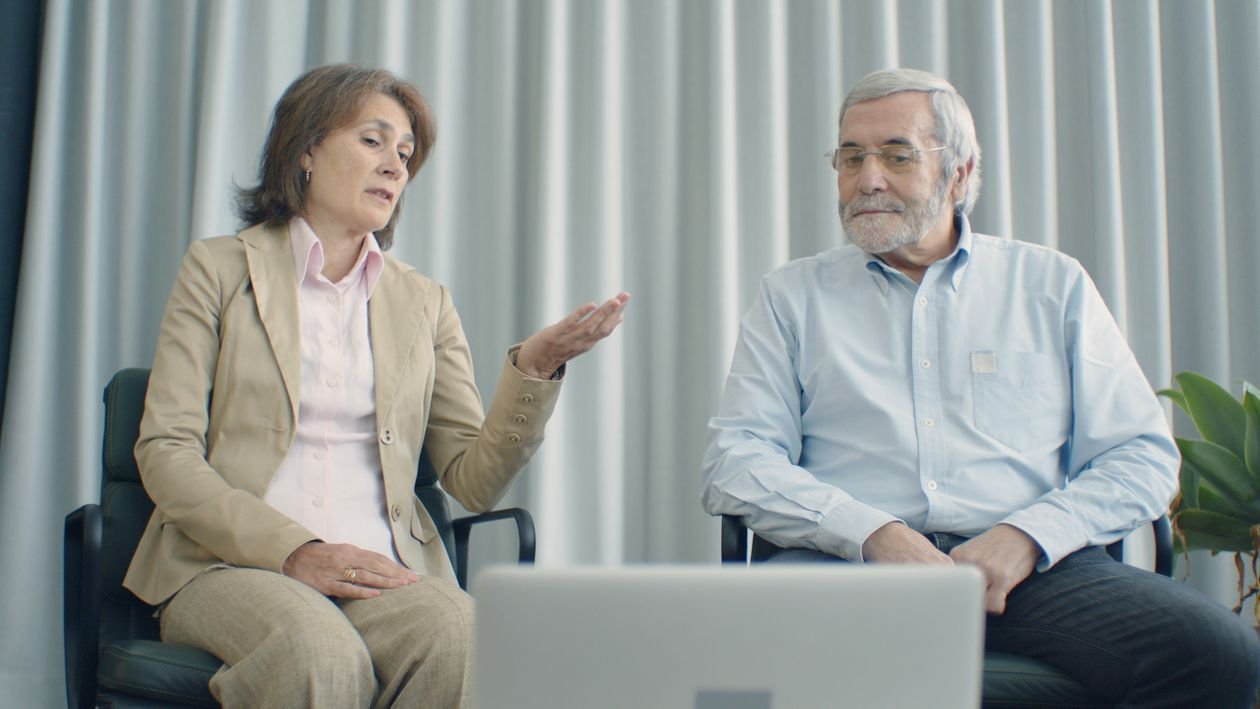 An older woman looking carefully at her phone before responding to a message