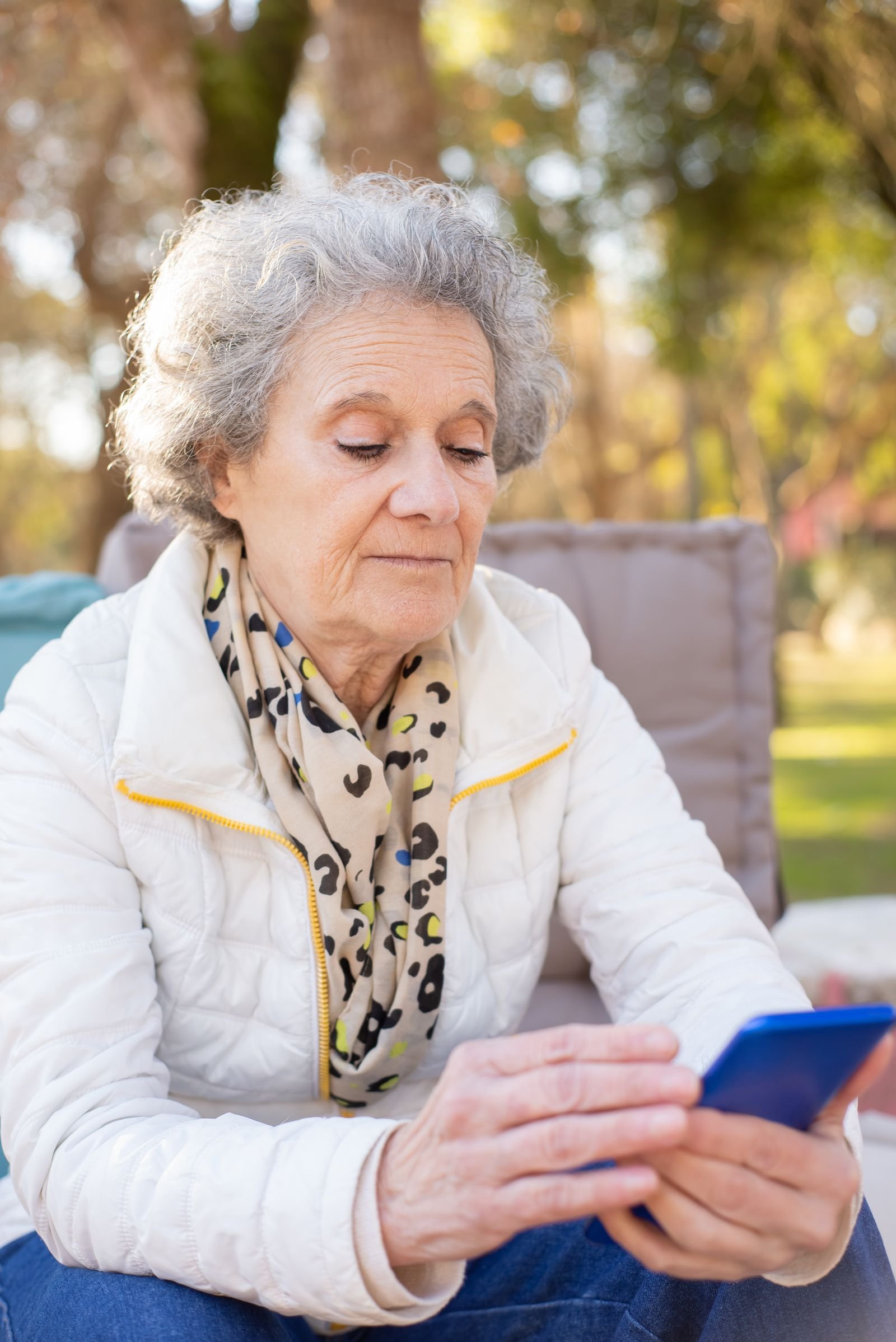 An older woman looking concerned while checking her phone