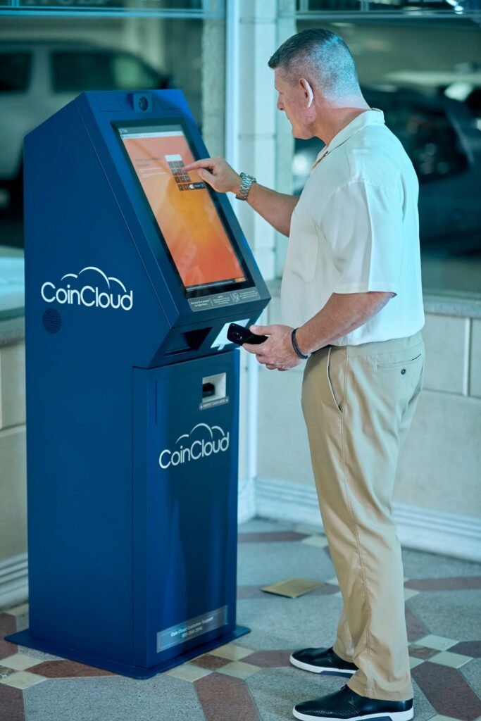 A senior man using a Bitcoin ATM kiosk